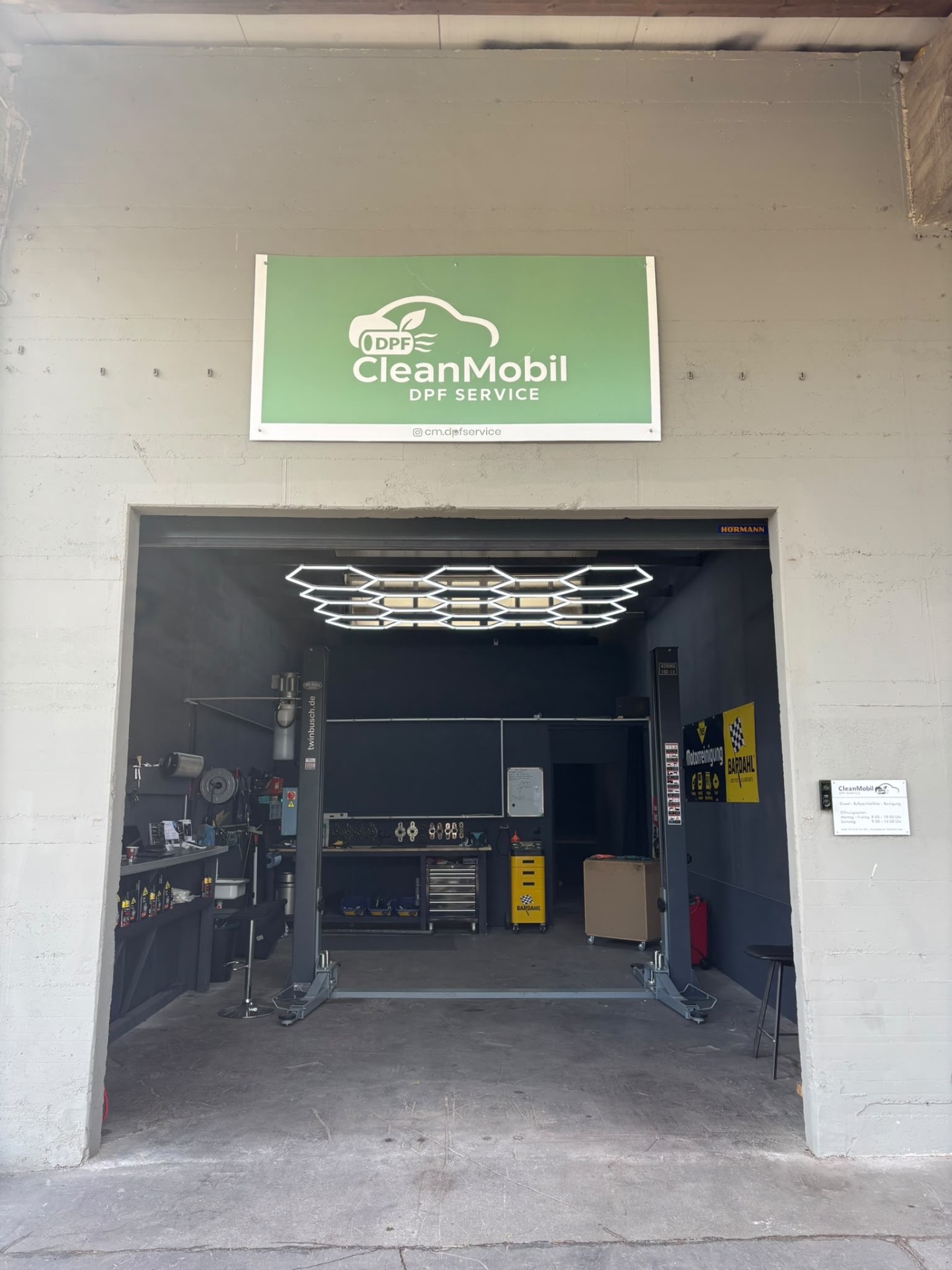 Eingang von CleanMobil DPF Service mit Firmenschild über dem Werkstatttor